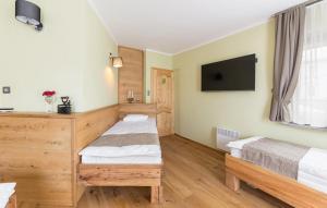 a room with two beds and a flat screen tv at Apartma Rozika in Ptuj