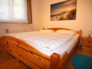 a wooden bed in a bedroom with a painting on the wall at Ferienwohnung, Trassenheide in Trassenheide