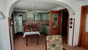 a kitchen with green cabinets and a table and chairs at Casa Gonano in Prato Carnico