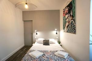 een slaapkamer met een groot bed met 2 kussens erop bij Le 12 * Hyper centre* in Lorient