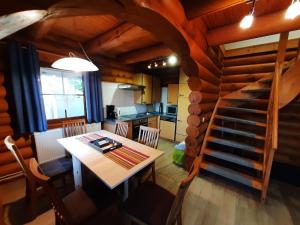 a dining room with a table and a spiral staircase at Log cabin in Harzgerode with balcony in Dankerode