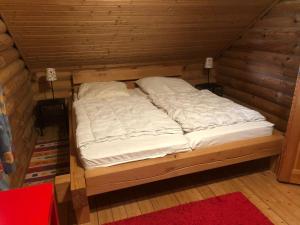 uma cama num quarto de madeira com duas almofadas em House, Wiefelstede-Lehe em Wiefelstede