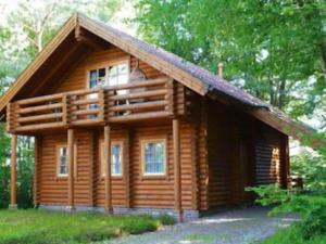 uma cabana de madeira com um telhado de gambrel em House, Wiefelstede-Lehe em Wiefelstede