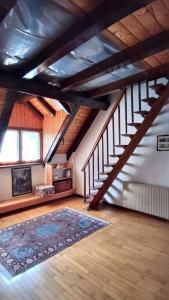 an attic room with a staircase and a rug at Casa Gonano in Prato Carnico