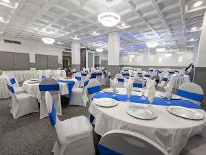 un salón de banquetes con mesas blancas y sillas azules en Red Roof Inn PLUS+ Wichita East, en Wichita