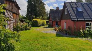 two houses with a grass yard in front of them at Farmors Hus in Rude