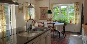 a kitchen with a sink and a table with chairs at Farmors Hus in Rude