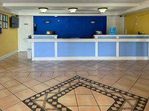 a lobby with a blue wall and a tile floor at Motel 6 Huntsville AL University Dr. in Huntsville