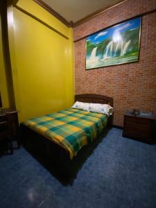 a bedroom with a bed in a brick wall at Hostal Suites Madrid in Guayaquil