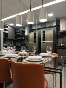 a kitchen with a table with chairs and wine glasses at A mais Charmosa acomodação em Boa Viagem. 500Mb in Recife