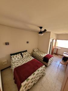 um quarto com 2 camas e uma ventoinha de tecto em Canastra Eco Hospedagem em São Roque de Minas