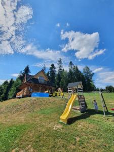 a playground with a slide on a hill with a house at Domek w górach pod Jodłami in Nowy Targ