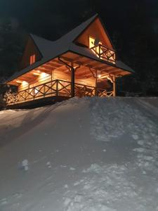 a log cabin in the snow at night at Domek w górach pod Jodłami in Nowy Targ