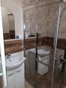 uma casa de banho com 2 lavatórios e uma cabina de duche em vidro. em Domek w górach pod Jodłami em Nowy Targ