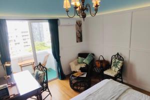 um quarto com uma cama e cadeiras e uma janela em Rambla Apart em Montevidéu