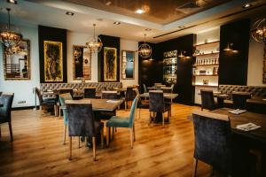 a restaurant with wooden floors and tables and chairs at Gran Hotel Don Manuel in Cáceres