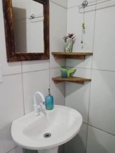 a bathroom with a white sink and a mirror at Casas do Manoel in Praia do Rosa
