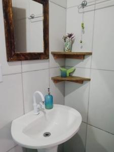 Un baño con un lavabo blanco y un espejo. en Casas do Manoel, en Praia do Rosa