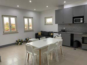 una cucina e un soggiorno con tavolo e sedie bianchi di Apartamento, Praça Dom Duarte 8, Viseu, Portugal a Viseu