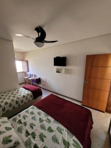 a bedroom with two beds and a ceiling fan at Canastra Eco Hospedagem in São Roque de Minas