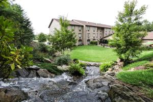 a garden with a stream in front of a building at The Lodge at Flat Rock in Upward