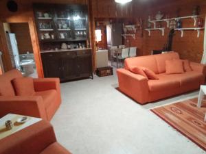 un salon avec deux canapés orange et une cuisine dans l'établissement casa ginefra, à Tito