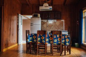 a kitchen with a table with chairs and a refrigerator at Cabañas Los Timbó in Ituzaingó