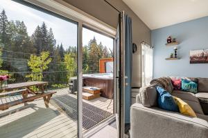 a living room with a sliding glass door leading to a deck at Pillow Top Condo by Revelstoke Vacations in Revelstoke