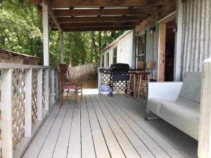 - une terrasse couverte avec un canapé, une table et des chaises dans l'établissement Twin Oaks, à Bryson City