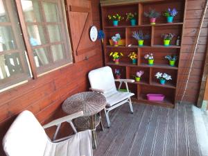 une terrasse couverte avec 2 chaises, une table et quelques plantes dans l'établissement casa ginefra, à Tito