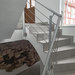 una escalera con una chimenea de piedra en una casa en Apartments & möblierte Zimmer in Kahl am Main, kontaktloser Self Check-in, W-Lan, Schreibtisch, Duschbad, Küchenzeile, PKW-Plätze, en Kahl am Main