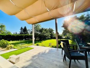 een patio met een tafel en stoelen en een parasol bij Lilac House - holiday and relaxation house in Ohrobec
