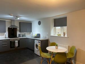 una cucina con tavolo, tavolo e sedie di Maple House 2 bed House with free parking in town by ShortStays4U a Kings Lynn