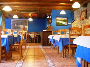a restaurant with blue walls and wooden tables and chairs at Bungalows La Borda d´Arnaldet in Villanova