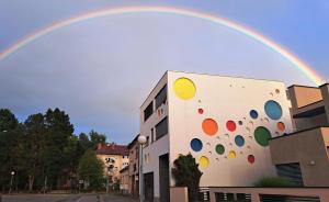 a rainbow over the side of a building with a building with at Arcobaleno Apartments & Rooms in Varaždin