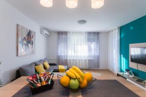 una sala de estar con un bol de fruta en una mesa en Apartman Lariva, en Osijek