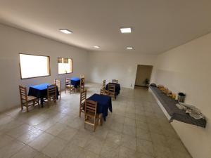 uma sala de jantar com mesas e cadeiras azuis em Canastra Eco Hospedagem em São Roque de Minas