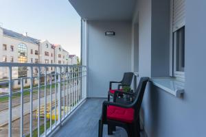 two chairs on a balcony with a view of a street at Apartman Lariva in Osijek