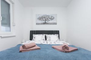 a bedroom with a bed with two towels on it at Apartman Lariva in Osijek