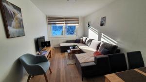 a living room with a couch and a table at Apartmani Jahorina Olimpijska kuca in Jahorina