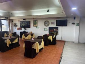 une salle avec deux tables avec des nappes jaunes et noires dans l'établissement Hotel Lerma, à Lerma de Villada