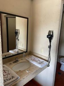 a bathroom with a sink and a phone on the wall at Hotel Lerma in Lerma de Villada