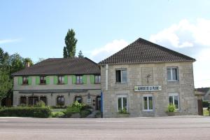 a large stone building on the side of a street at Auberge De La Plaine in La Rothière