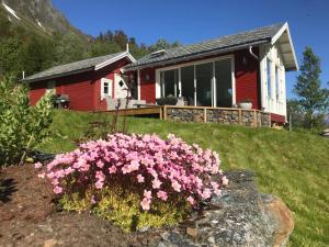 a house with pink flowers in front of it at Kjosen Lodge, Lyngen. in Lyngseidet