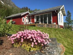 ein Haus mit rosa Blumen davor in der Unterkunft Kjosen Lodge, Lyngen. in Lyngseidet