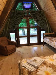 Habitación con cama y TV en una cabaña en Бунгало en Kheivani