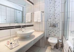 a bathroom with a toilet, sink, and mirror at Grand Halic Goldenhorn in Istanbul