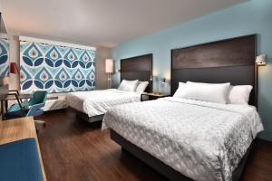 a hotel room with two beds and a chair at Tru By Hilton Beckley, Wv in Beckley