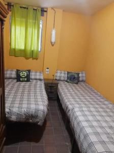 - 2 lits dans une chambre avec des rideaux verts dans l'établissement R U Ready Fishing, River Ebro, à Mequinenza