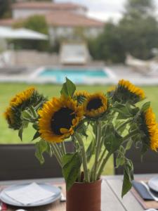 a vase filled with sunflowers sitting on a table at Le domaine des Petits Princes in Lorgues